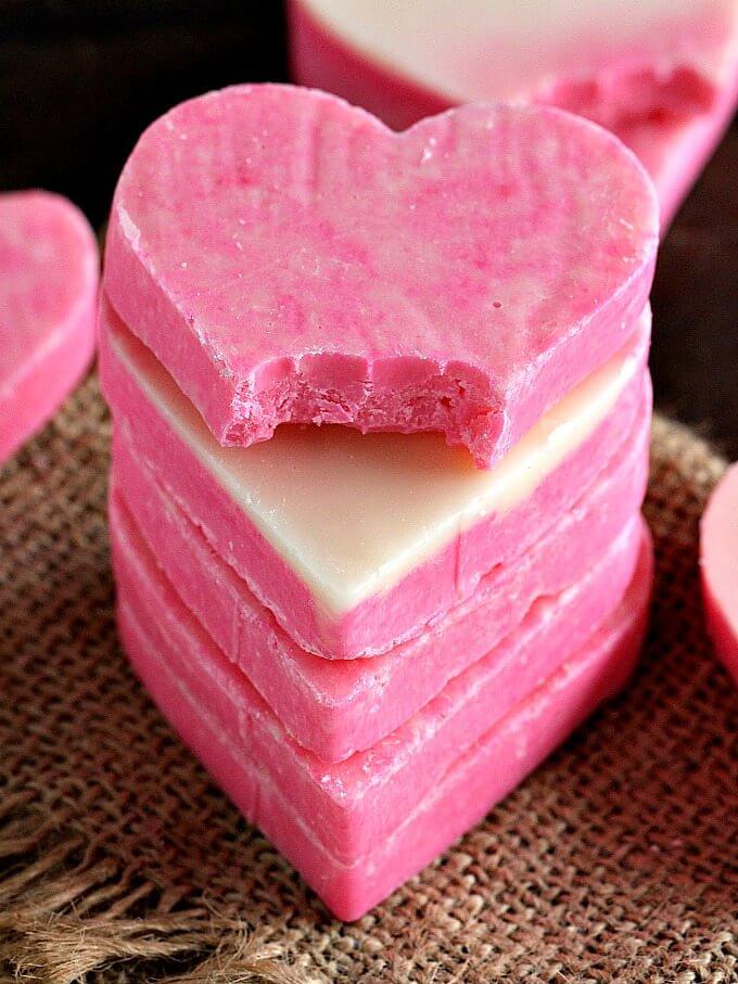 stack of heart-shaped pink white chocolate fudge with one with a bite taken