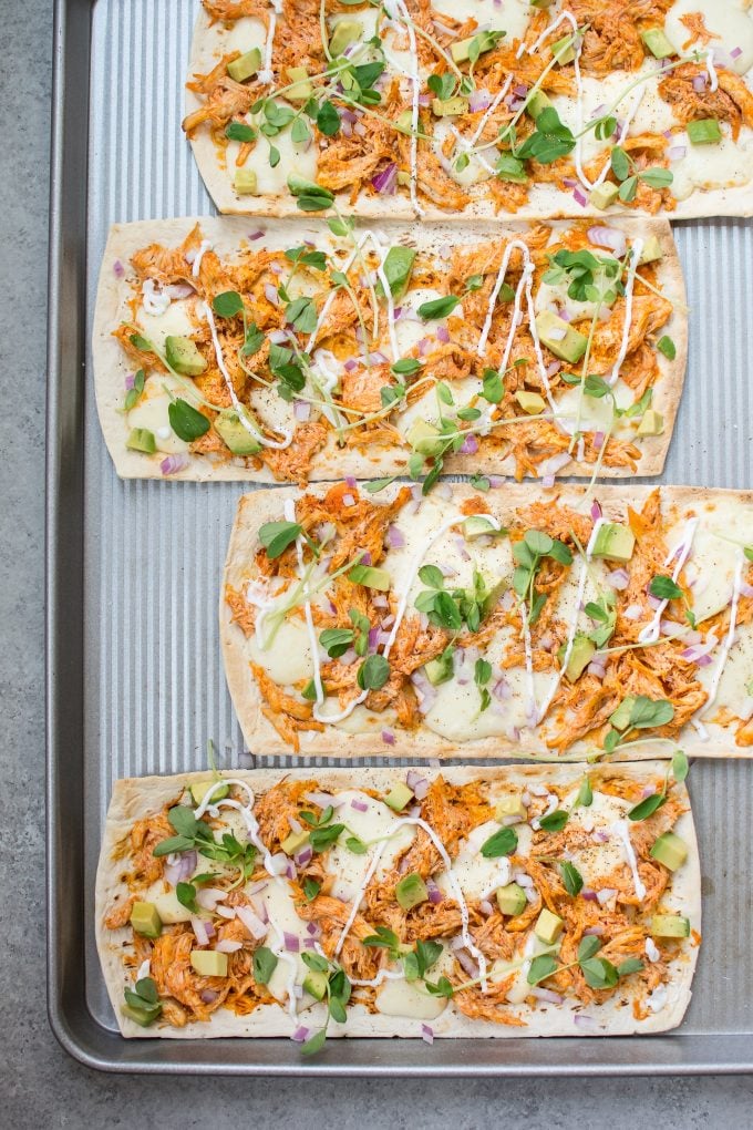 skinny buffalo chicken flatbread pizza on a baking sheet