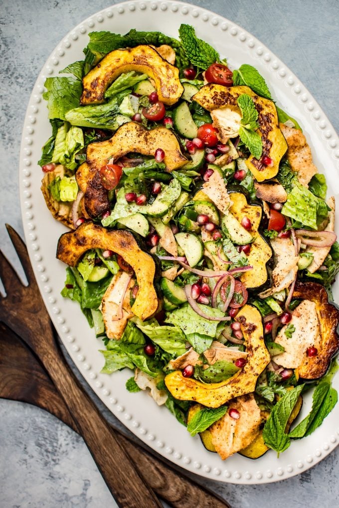 serving platter of fall fattoush salad with wooden salad utensils