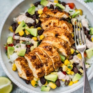 These spicy chicken taco bowls are simple, healthy, and delicious. Spicy southwest seasoning, fresh toppings, and a tangy creamy drizzle make these bowls irresistible!