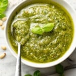 a bowl of homemade pesto sauce with a spoon