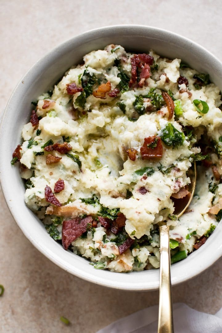 close-up of Colcannon Irish mashed potatoes and kale with bacon in a bowl with a spoon