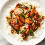 a bowl with mongolian chicken over rice