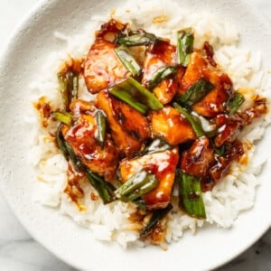 a bowl with mongolian chicken over rice