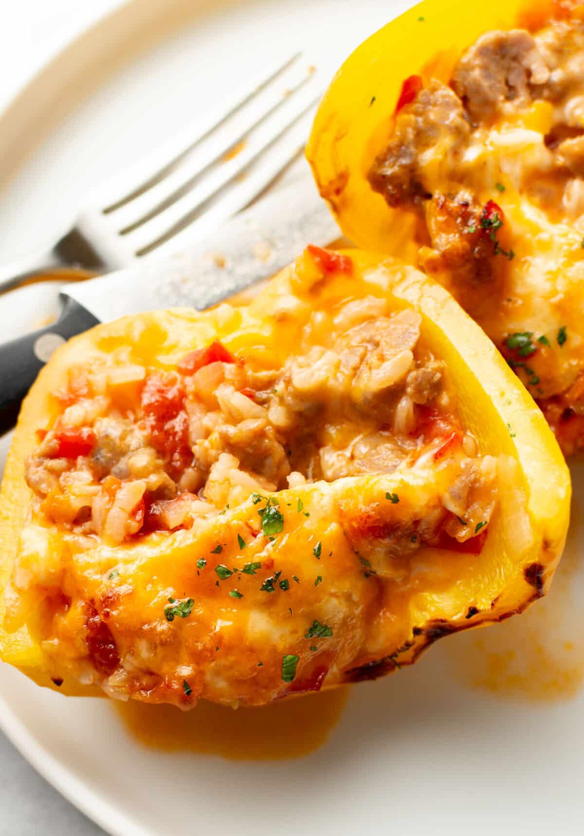 a plate with a sausage stuffed bell pepper cut in half