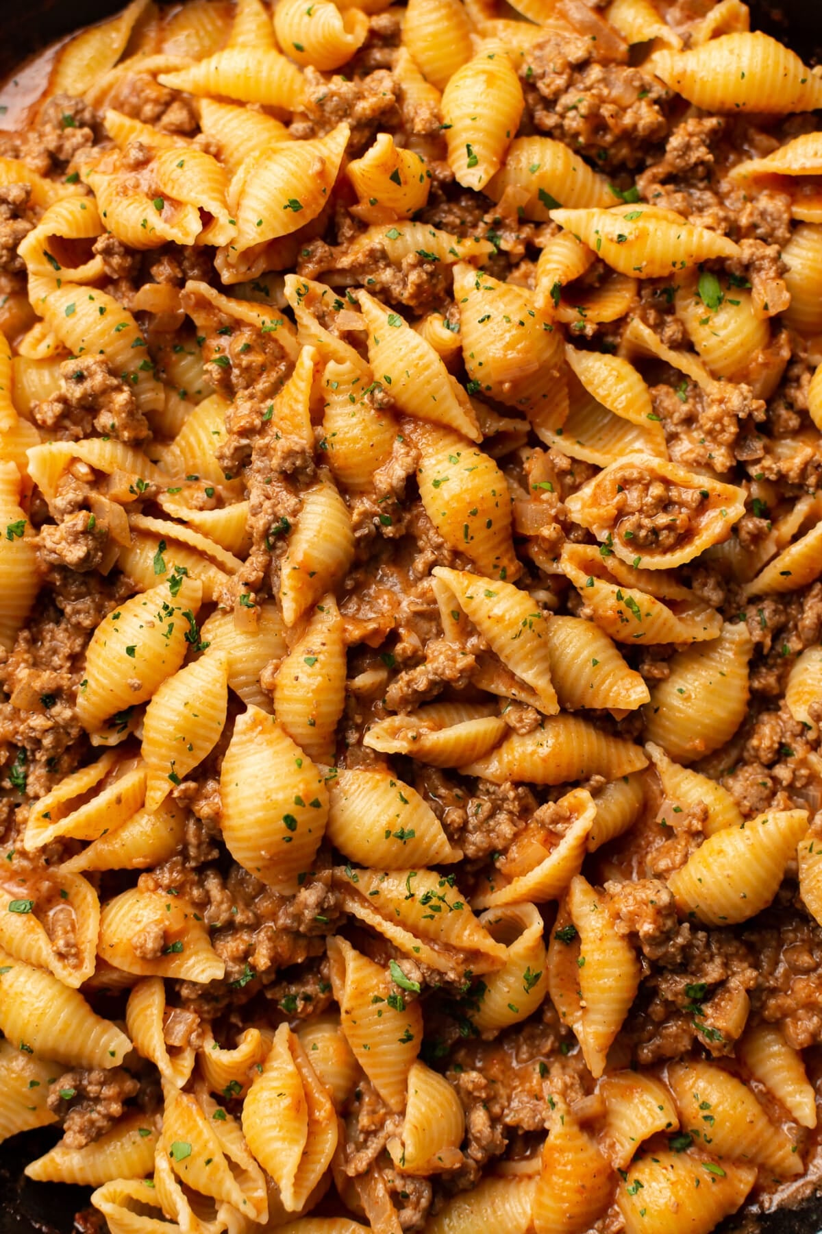 closeup of a skillet with pasta in a creamy beef sauce