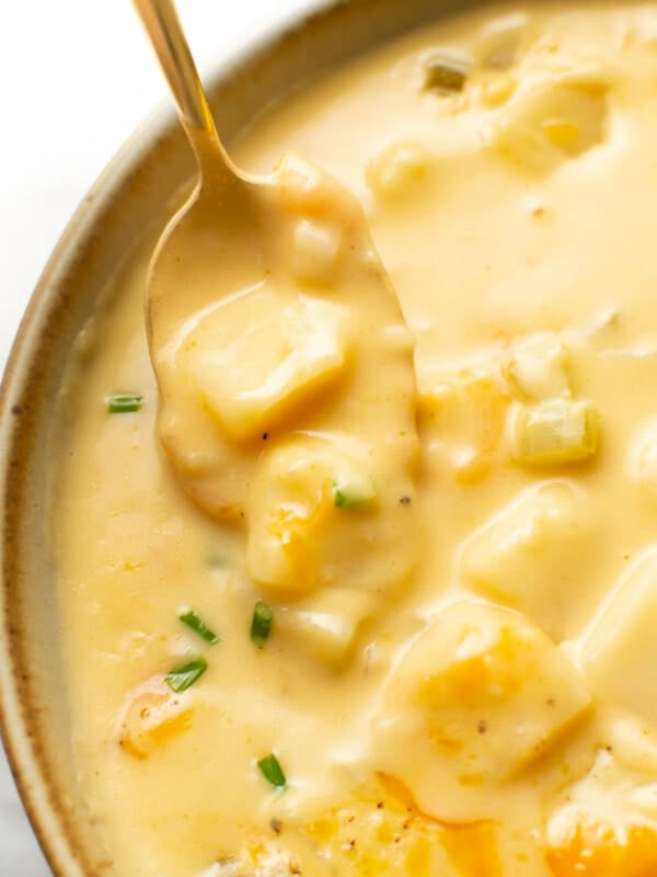closeup of a bowl of cheesy potato soup with a spoon