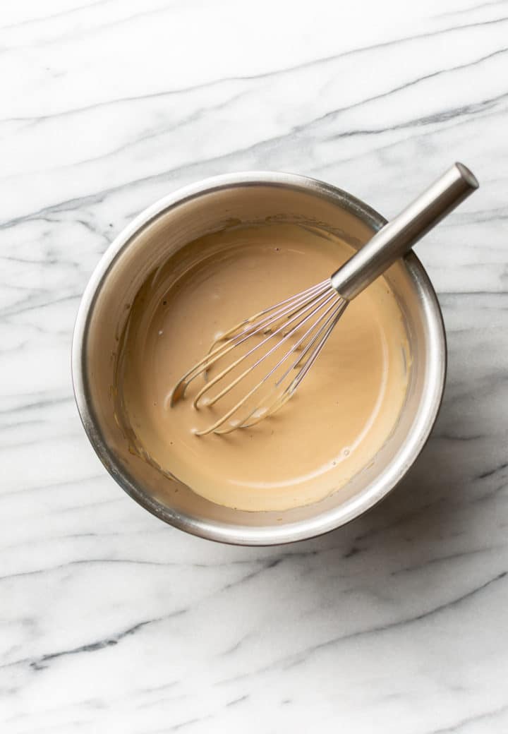 creamy balsamic salad dressing in a metal prep bowl with a whisk