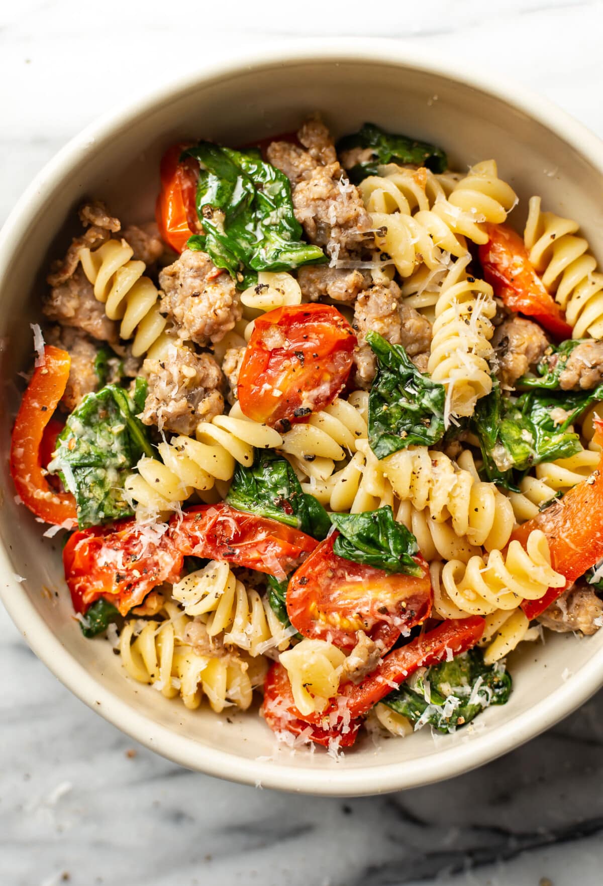 a bowl of sausage and vegetables pasta