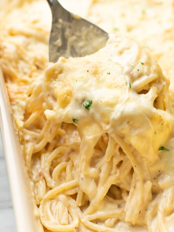 closeup of a casserole dish with ranch chicken spaghetti and a serving spoon
