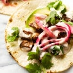 two steak tacos on a marble surface