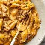 a bowl with cheesy beef and shells and a fork