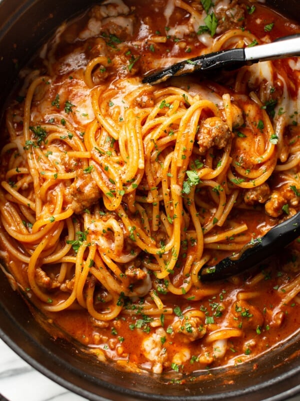 one pot italian sausage pasta with serving tongs