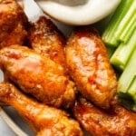 a plate of air fryer buffalo chicken wings with ranch dip and celery sticks