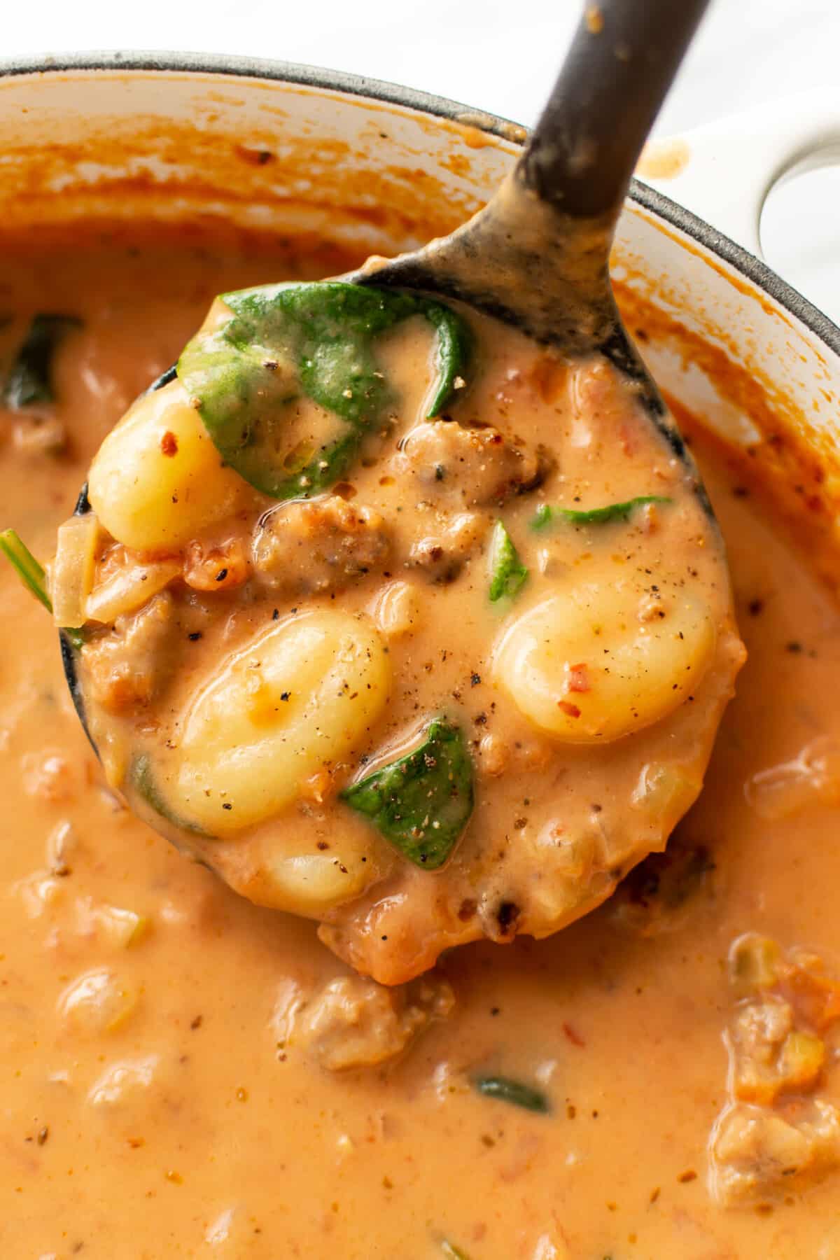 a ladle with creamy italian sausage gnocchi soup