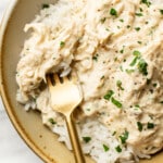 a bowl of crockpot ranch chicken with rice and a fork
