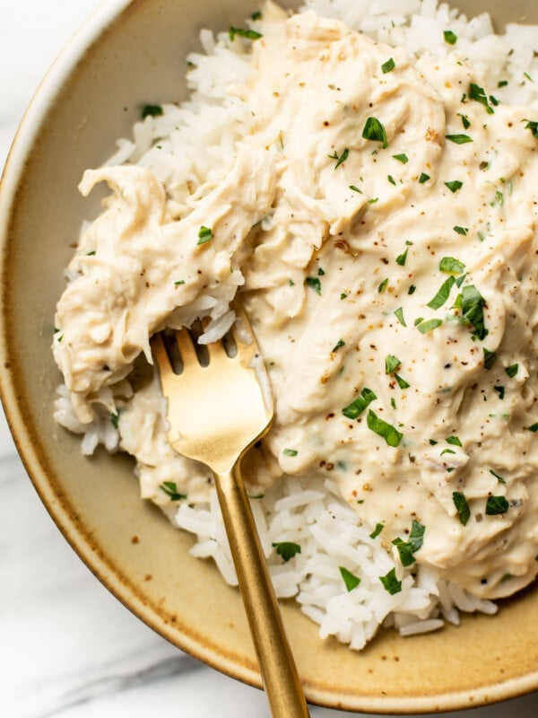 a bowl of crockpot ranch chicken with rice and a fork