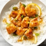 a bowl of chinese lemon chicken over rice