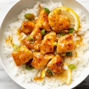 a bowl of chinese lemon chicken over rice