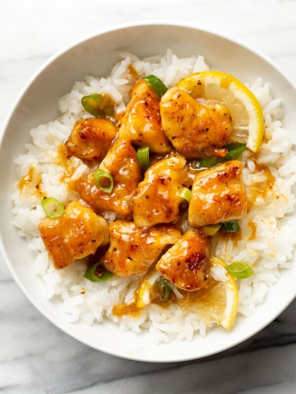 a bowl of chinese lemon chicken over rice