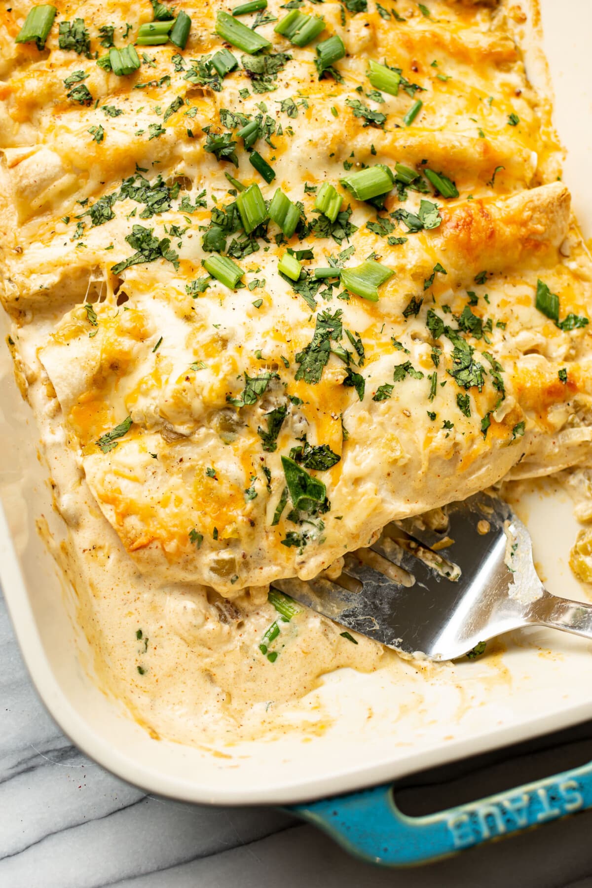 a baking dish with chicken enchiladas