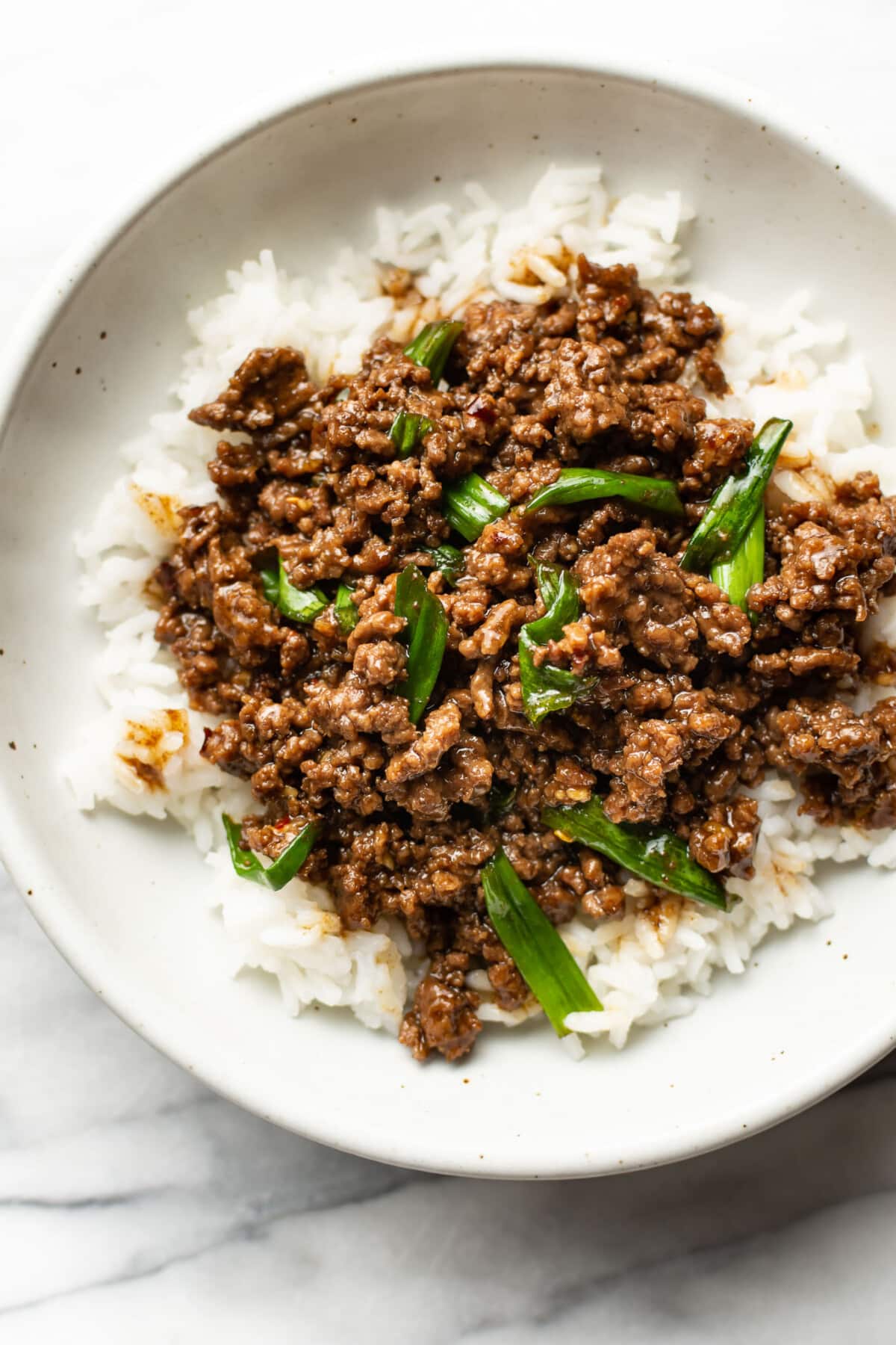 a bowl of mongolian ground beef over rice