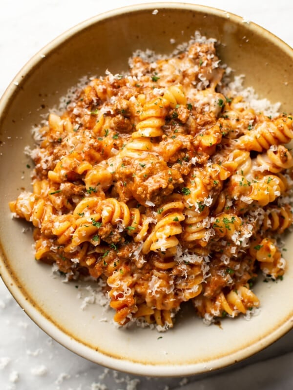 a bowl of rotini pasta with a cheesy tomato and meat sauce