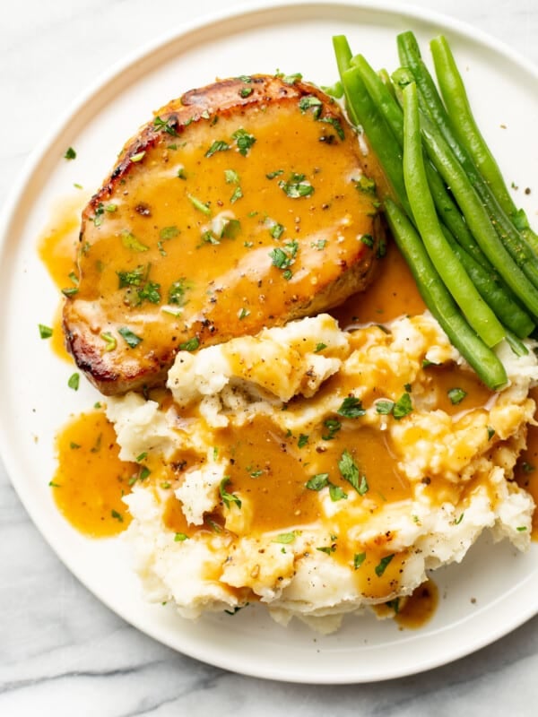 a plate with honey mustard pork chop, green beans, and mashed potatoes