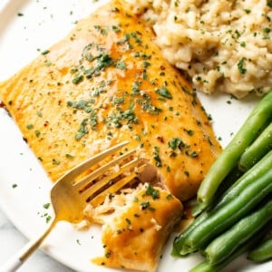 a plate with arctic char, risotto, green beans, and a fork