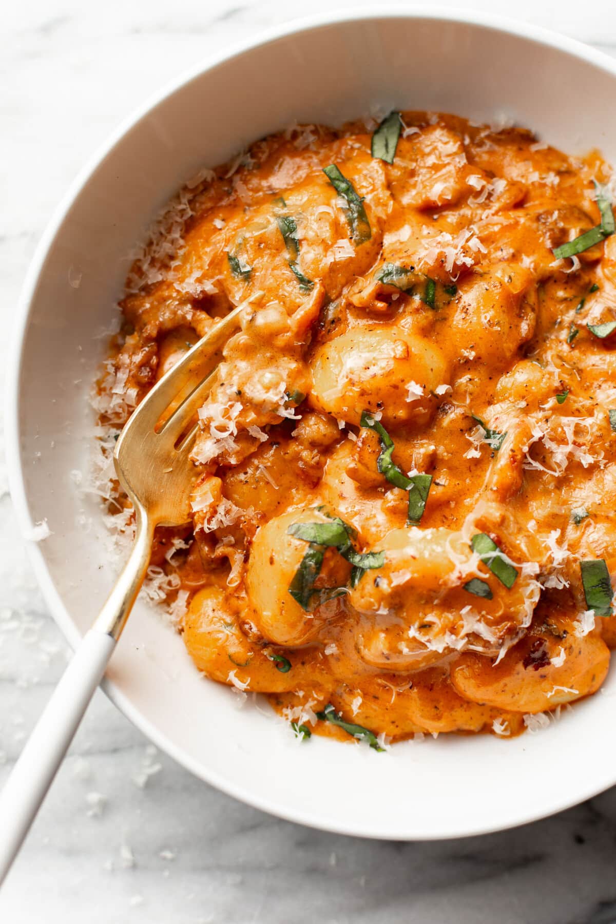 a bowl of spicy tomato gnocchi with a fork