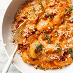 a bowl of spicy tomato gnocchi with a fork