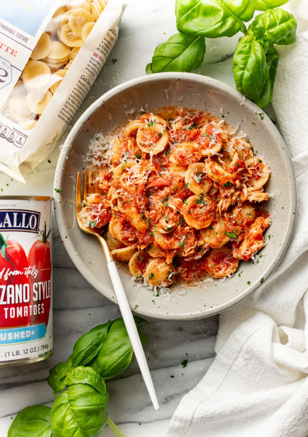 a bowl of chicken fra diavolo pasta next to ingredients