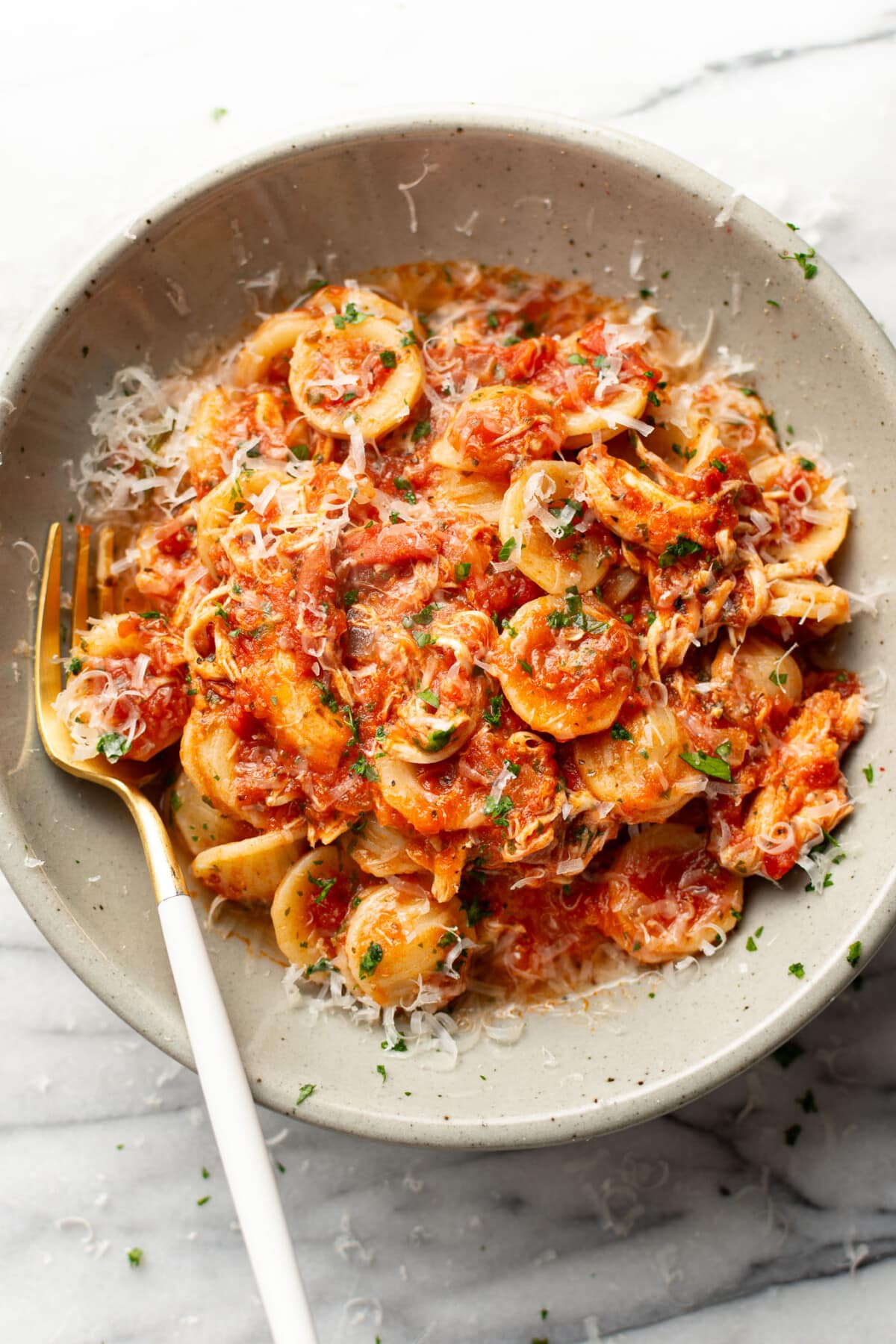 a bowl of chicken fra diavolo pasta with a fork