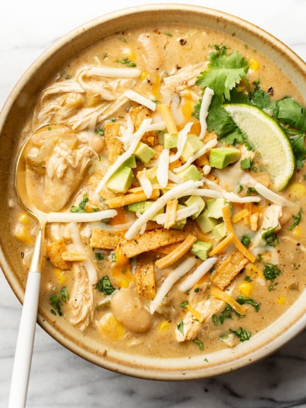 a bowl of creamy green chicken enchilada soup with a spoon