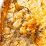 closeup of ground beef and potato casserole with a serving spoon