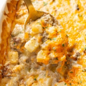 closeup of ground beef and potato casserole with a serving spoon