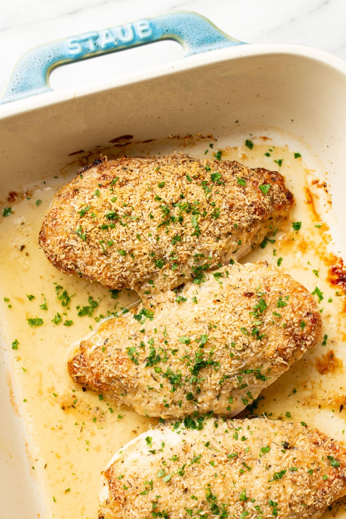 a casserole dish with baked parmesan chicken