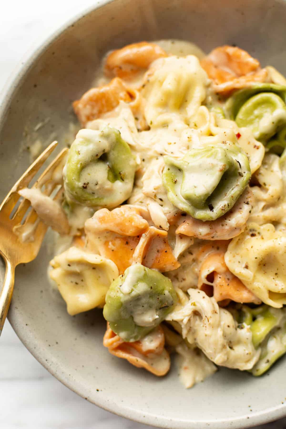 a bowl with pesto chicken tortellini