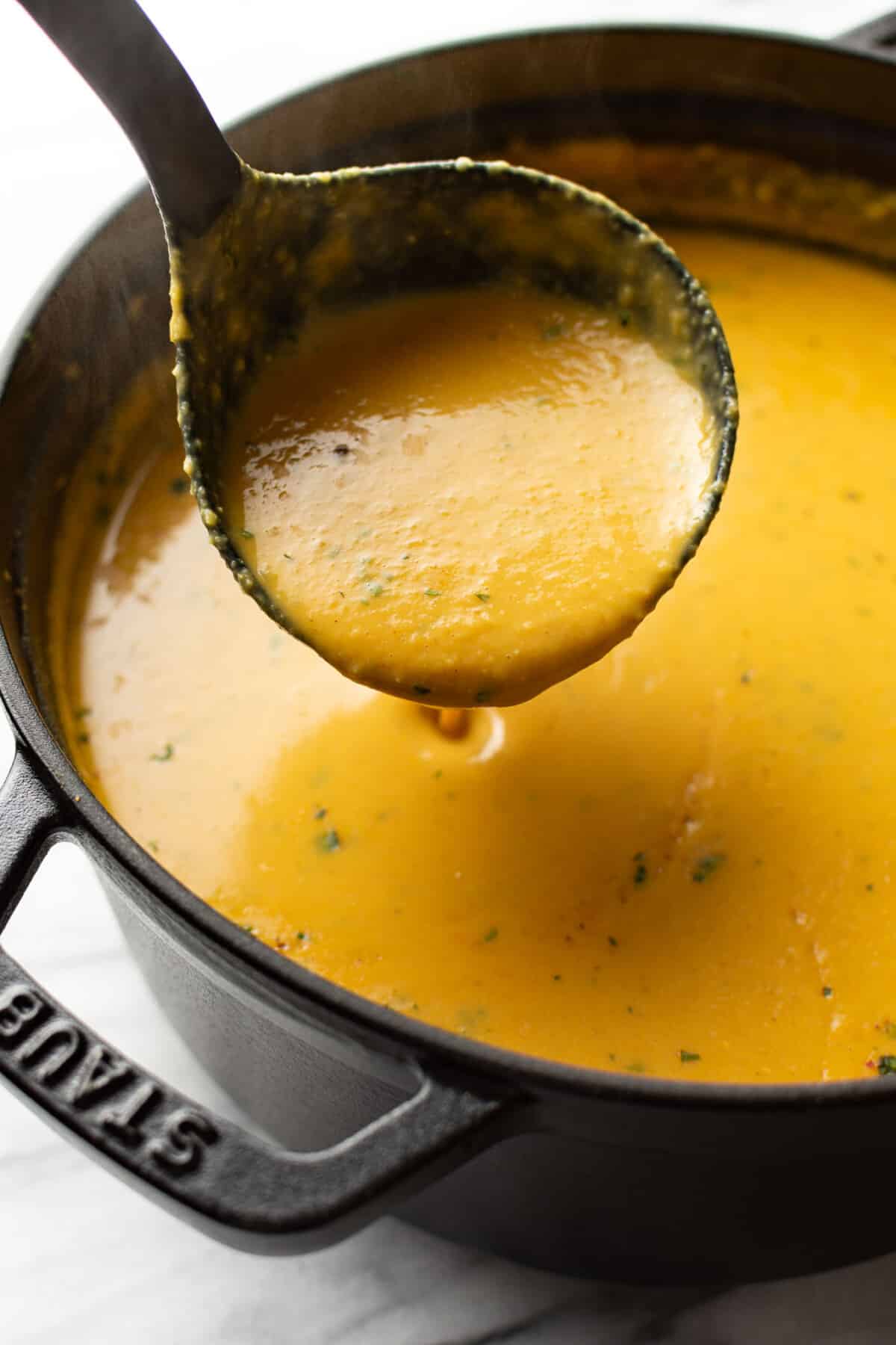 a pot of spicy lentil soup with a ladle