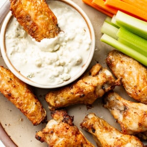 buffalo wings on a plate with homemade blue cheese dressing, carrots, and celery